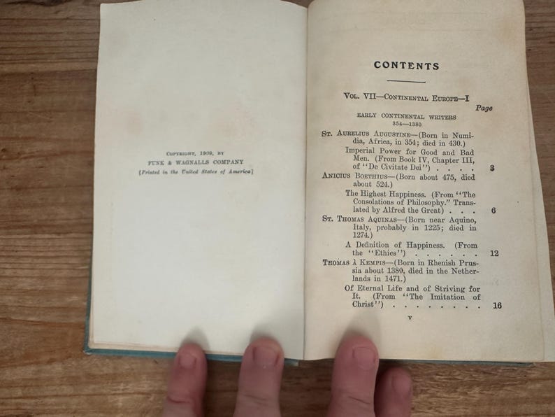 May include: Open book with the title "CONTENTS" and a list of early continental writers. The book is open to a page with text, including "St. Aurelius Augustine" and "St. Thomas Aquinas". The book is printed by Funk & Wagnalls Company.