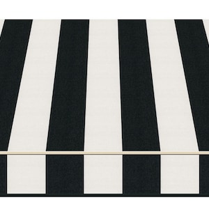 Pode incluir: Uma caixa retangular com um padrão de listras pretas e brancas. As listras correm verticalmente na parte superior e nas laterais da caixa. A caixa tem uma borda de cor clara.