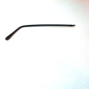 May include: A black plastic glasses arm, or temple, with a curved shape.