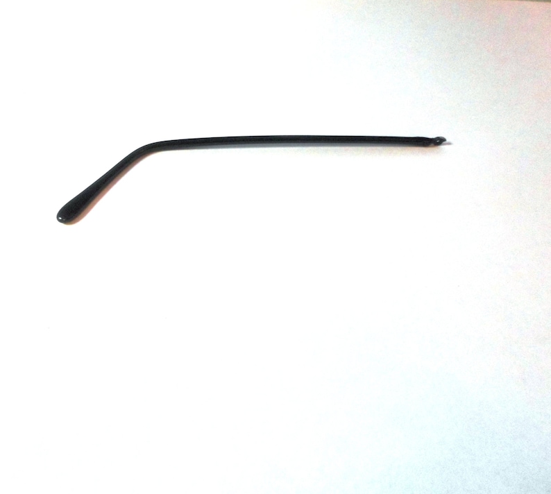 May include: A black plastic glasses arm, or temple, with a curved shape.
