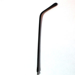 May include: A black plastic replacement temple arm for eyeglasses.