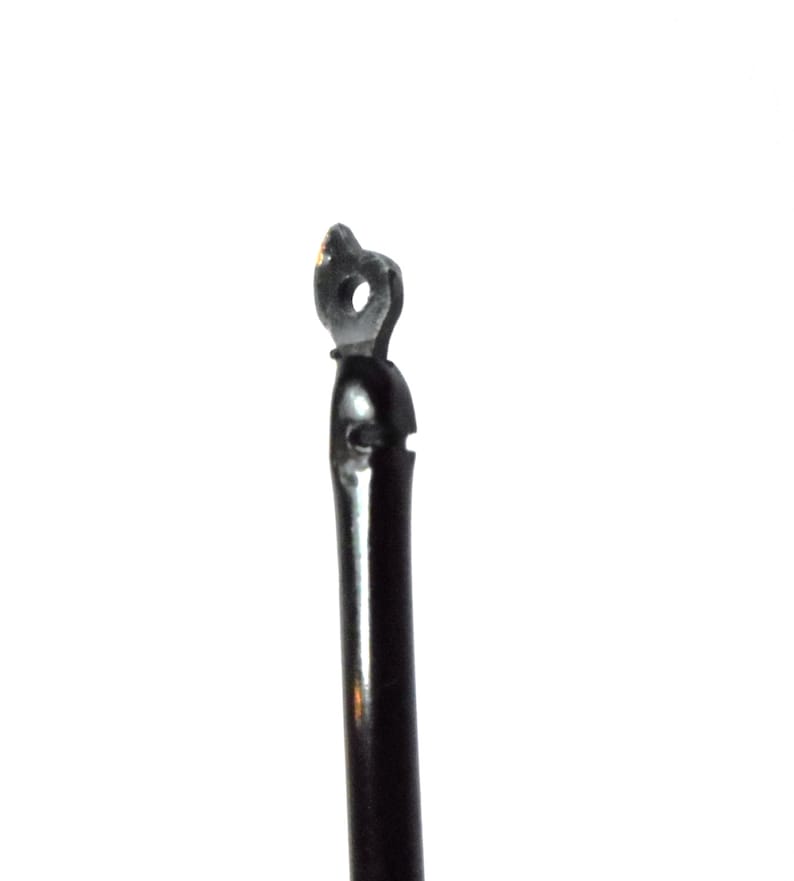 May include: Close-up of a black metal hook with a small loop at the top.