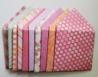 May include: A set of ten pink and white patterned envelopes with various designs, including polka dots, stripes, and floral patterns. Some envelopes have text that says "I love you" and "I am yours".
