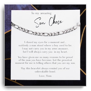 Peut inclure: Un bracelet à chaîne argenté présenté sur une carte avec un motif géométrique bleu marine et doré. La carte porte l'inscription "To my amazing Son Chase" et un message de "Maman".