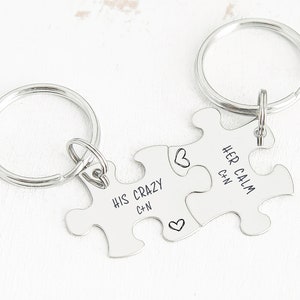 May include: Two silver puzzle piece keychains with the text "His Crazy C+N" and "Her Calm C+N" on them.