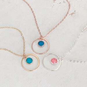 Puede incluir: Tres delicados collares con colgantes circulares que presentan peque&ntilde;as piedras preciosas azules, rosas y turquesas. Los collares est&aacute;n hechos de cadena dorada, oro rosa y plata.