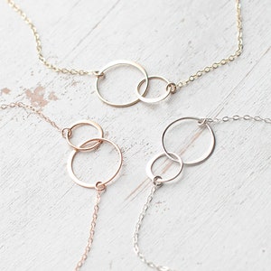 Puede incluir: Tres delicados collares con colgantes de c&iacute;rculo entrelazados. Los collares est&aacute;n hechos de cadena dorada, oro rosa y plata.