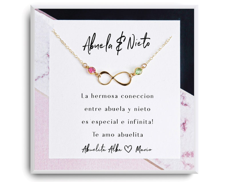 May include: Gold infinity necklace with pink and green gemstones. The card reads "Abuela & Nieto" and "La hermosa conexi&oacute;n entre abuela y nieto es especial e infinita! Te amo abuelita Abuelita Alba Mario".