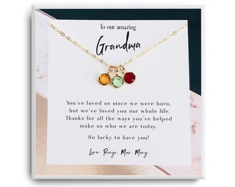 May include: A gold necklace with three colorful charms in a white box with a message to Grandma. The message reads: "To our amazing Grandma You've loved us since we were born, but we've loved you our whole life. Thanks for all the ways you've helped make us who we are today. So lucky to have you! Love. Rocyo. Max. Mary"