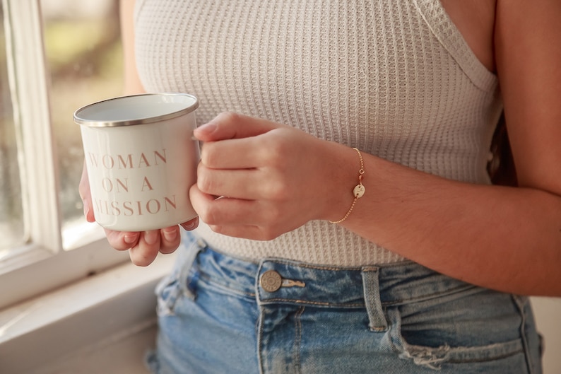 May include: White enamel mug with a pink inscription that reads "Woman on a Mission".