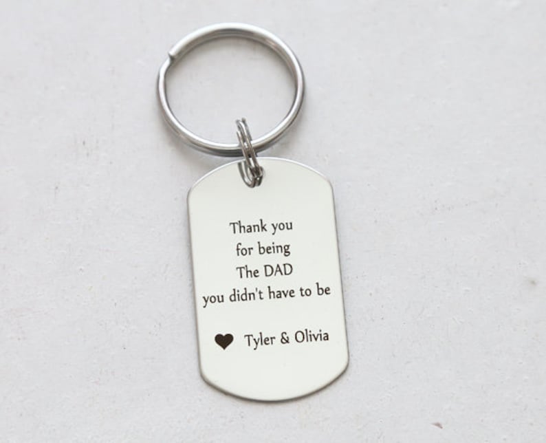 May include: Silver keychain with a tag that reads "Thank you for being The DAD you didn't have to be Tyler & Olivia".