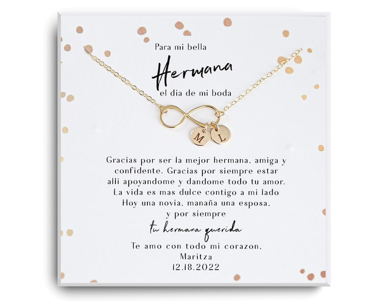 May include: A gold infinity necklace with two charms, one with the letter "M" and the other with the letter "L". The necklace is displayed on a white card with a message in Spanish that reads "Para mi bella Hermana el dia de mi boda" and "Gracias por ser la mejor hermana, amiga y confidente. Gracias por siempre estar alli apoyandome y dandome todo tu amor. La vida es mas dulce contigo a mi lado Hoy una novia, mana&ntilde;a una esposa. y por siempre tu hermana querida Te amo con todo mi corazon, Maritza 12.18.2022".