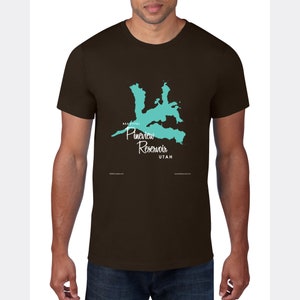 May include: A brown t-shirt featuring a teal graphic of Pineview Reservoir in Utah. The text "BEAUTIFUL Pineview Reservoir UTAH" is printed on the shirt. The shirt is a crew neck style.