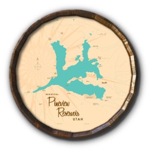 May include: A round wooden sign featuring a map of Pineview Reservoir in Utah. The reservoir is teal, set against a beige background with radiating lines. The sign's text reads "Beautiful Pineview Reservoir Utah."
