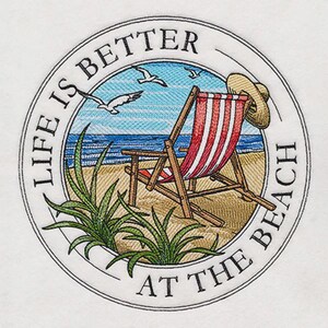 May include: Circular design with the text "LIFE IS BETTER AT THE BEACH". The image features a beach scene with a red and white striped beach chair, a straw hat, seagulls, and green plants. The background shows the ocean and sky.