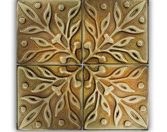 Puede incluir: Cuatro azulejos de latón con un diseño floral, ligeramente teñidos en tonos marrones y dorados.