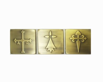 Baldosas metálicas con forma de cruz, de estilo asturiano, bretón y con diseños de Santiago Apóstol, en cobre, latón y acero.
