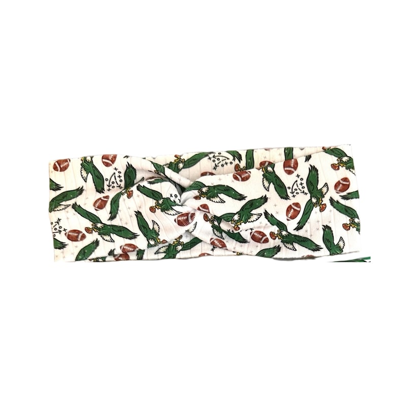 May include: White headband with a green and brown pattern of eagles and footballs.