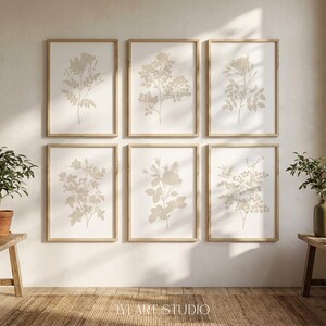May include: A set of six rectangular wall art prints in light wood frames, each featuring a beige botanical illustration of flowers and leaves on a white background. The prints are arranged in two rows of three, with the text IVY ART STUDIO at the bottom.