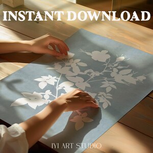May include: A rectangular print featuring a white botanical illustration of flowers and leaves on a muted blue background. The text INSTANT DOWNLOAD is printed in white at the top, and the text IYI ART STUDIO is printed in white at the bottom.