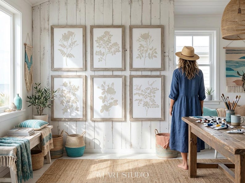 May include: A set of six framed botanical prints featuring beige floral illustrations on a white background, arranged in two rows of three on a white vertical wood paneled wall, with light wood frames surrounding each individual artwork piece.