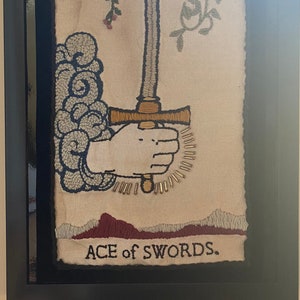 Carta de tarô bordada à mão e com miçangas. Ás de Espadas. Emoldurado (sem vidro) 13 x 9”