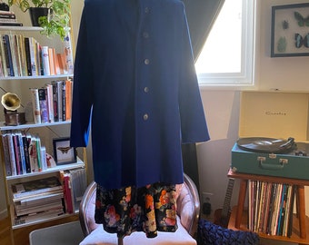 1980s cobalt blue wool winter coat. Hidden front button placket. Lined with a blue/purple nylon lining. Size 11/12. Tags pictured.