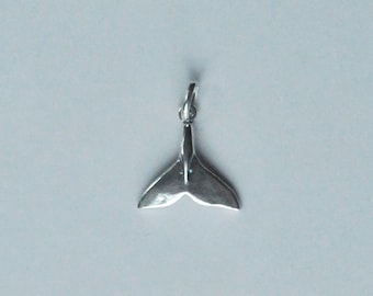 Può includere: Ciondolo a forma di coda di balena in argento. La coda è un design semplice con una finitura liscia e lucida.