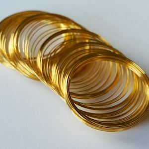 May include: A stack of gold-colored metal rings, likely for jewelry making or crafting.