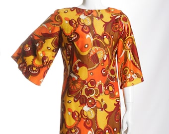 May include: A vintage dress with a bold, abstract print in shades of orange, yellow, brown, and white. The dress has a round neckline and three-quarter sleeves.