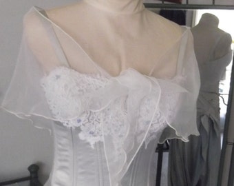 May include: A white satin wedding dress with a lace and tulle overlay. The dress has a fitted bodice and a flowing skirt.