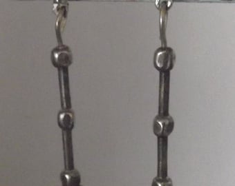 Aros colgantes de plata laminada y cristal rojo rubí, de largo medio, con un cierre de bola perforada en plata.