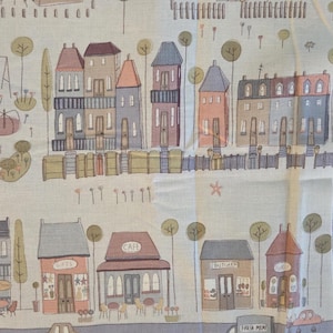 Może przedstawiać: Panel materiału przedstawiający fantazyjną scenę wioski z domami, sklepami, drzewami i pociągiem. Ilustracja jest w miękkich pastelowych kolorach, ze szczegółami takimi jak kawiarnia, sklep mięsny i samochody.