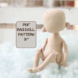 Puede incluir: Un patrón de muñeca de trapo de tela beige para una muñeca de 23 cm. El patrón está impreso en un fondo blanco con el texto "PDF RAG DOLL PATTERN 9" en texto marrón.