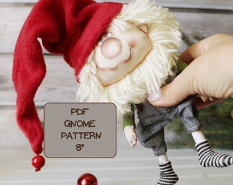 May include: A red and white gnome doll with a long red hat and a white beard. The doll is 8 inches tall and is holding a sign that says "PDF Gnome Pattern 8".