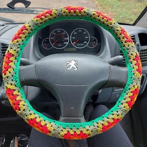 A  crocheted steering wheel cover, made from 12 granny squares in colours yellow, orange, red,  light green,khaki green and forest green.
