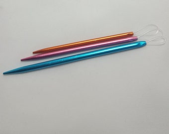 May include: Three sets of knitting needles in blue, pink, and orange. The needles are packaged in plastic and labeled "Knit Pro" with the text "Wool Needles".