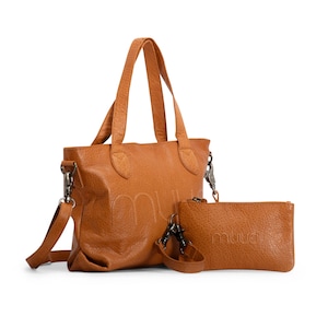 May include: A brown leather tote bag with a matching brown leather pouch. The bag has a shoulder strap and the pouch has a zip closure. Both items have the word "muud" embossed on them.