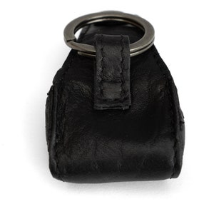 May include: Black leather key chain with a silver metal ring.