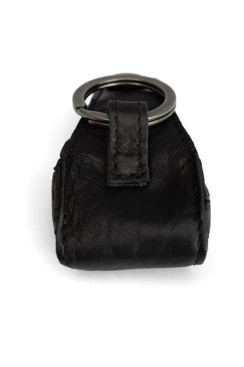 May include: Black leather key chain with a silver metal ring.