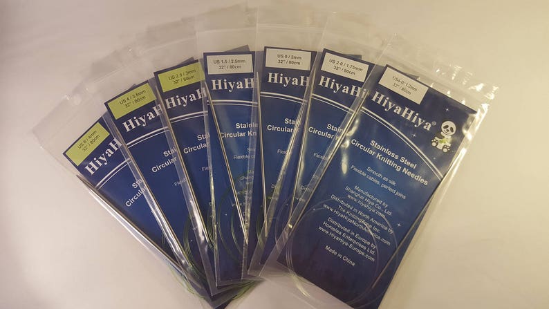 May include: A set of HiyaHiya stainless steel circular knitting needles in various sizes, packaged in clear plastic bags. The needles are smooth and flexible, perfect for knitting projects.