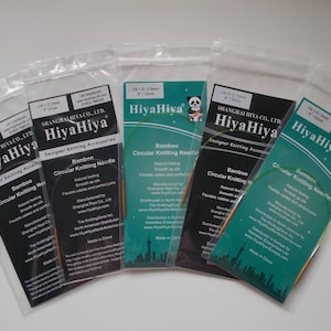 May include: Five packages of HiyaHiya bamboo circular knitting needles in various sizes. The packages are labeled with the size of the needles in US and mm, and the brand name HiyaHiya. The needles are made of natural bamboo and have smooth, flexible cables.