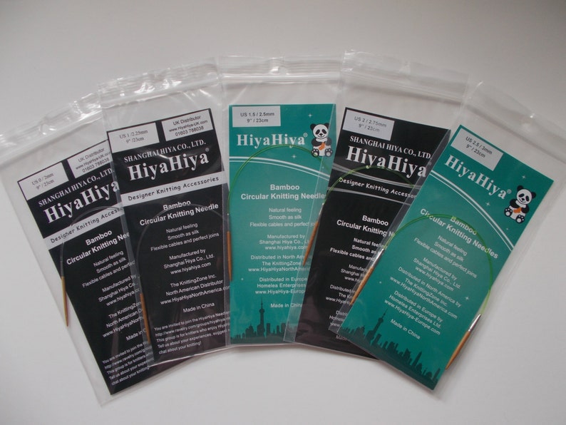May include: Five packages of HiyaHiya bamboo circular knitting needles in various sizes. The packages are labeled with the size of the needles in US and mm, and the brand name HiyaHiya. The needles are made of natural bamboo and have smooth, flexible cables.