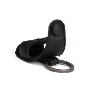 May include: Black leather key chain with a metal ring. The key chain has a loop for attaching keys.
