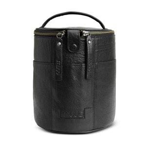 May include: Black leather cylindrical bag with a top handle and two zipper closures. The bag has a small pocket on the front and the word "muud" embossed on the bottom.