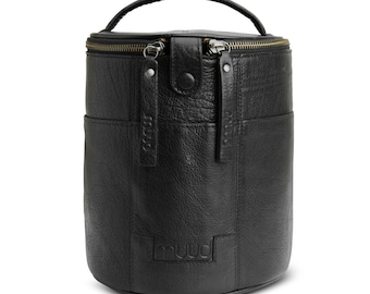 May include: Black leather cylindrical bag with a top handle and two zipper closures. The bag has a small pocket on the front and the word "muud" embossed on the bottom.