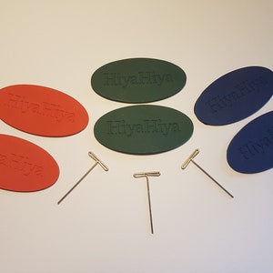Peut inclure: Cinq aiguilles à tricoter ovales de la marque HiyaHiya en vert, bleu et orange. Trois pointes d'aiguilles à tricoter en T dorées sont également incluses.