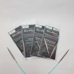 May include: Four packages of HiyaHiya Sharp stainless steel circular knitting needles. The packages are on a white surface with a turquoise blue cord.