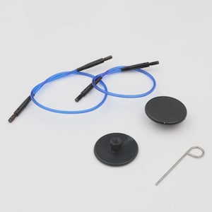 Peut inclure: Un ensemble d'aiguilles à tricoter avec des câbles bleus, des connecteurs noirs et deux disques circulaires noirs. Un outil en métal argenté est également inclus. L'ensemble est conçu pour les projets de tricot.