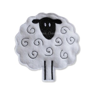 Puede incluir: Aplique de oveja de fieltro blanco con ojos, nariz y patas bordados en negro. La oveja tiene un diseño de lana rizada.